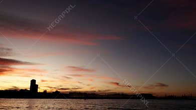 Panning video of a sunset on the beach with colorful clouds