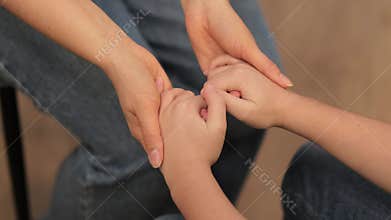 The supportive grip of an adult on a young boy's hands delivers reassurance, showcasing the impact of empathy in