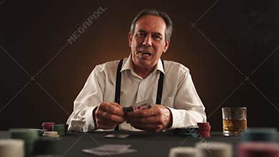 Strategic elderly man with cigar engrossed in poker, betting chips in dark room.