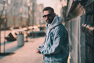 man in hoodie on a street sad