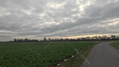 Car ride to the horizon between fields and meadows and clouds