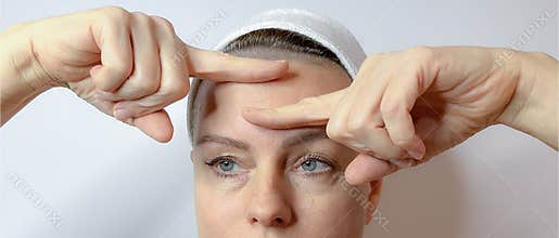 portrait of a mature woman with a bandage on her head and hands near her face