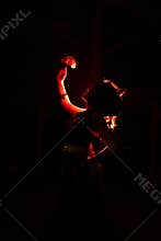the silhouette of a female dancer holding jewelry that looks like a reflection reflecting in the dim light
