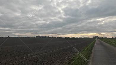 Car ride to the horizon between fields and meadows and clouds