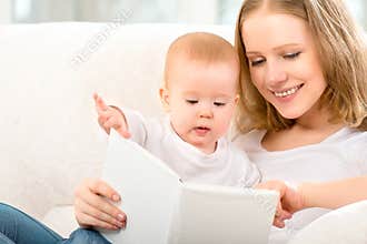 Mother reading a book a little baby on the sofa