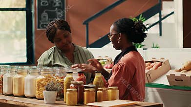 Retailer showing additives free organic sauces and seeds to client