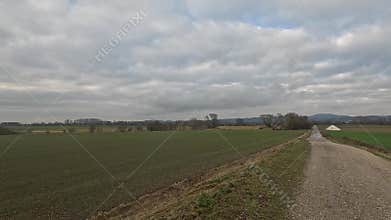 Car ride to the horizon between fields and meadows and clouds