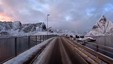 Winter's embrace is palpable as you drive on the snow-laden roads of Lofoten, Norway, where each turn unveils a new