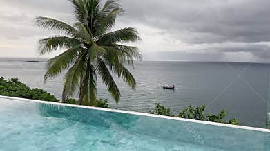 Incredible picturesque storm sky above still sea on coast of Thailand at cloudy weather, fishing boat, coconut palm tree