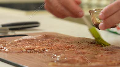 Chef is seasoning beaten chicken fillet with pepper salt and soy sauce