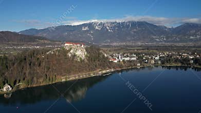 Lake Bled with the castle and the mountains aerial fly away