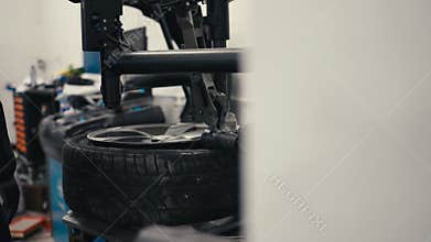 Winter and summer car tire change. Mechanic man in the repair shop puts the tire