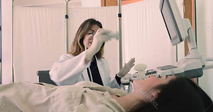 Female endocrinologists use ultrasound equipment to check patient thyroid gland