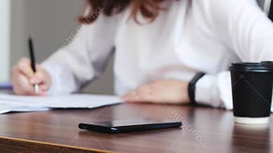 Writing, phone and papers with hands of young woman in home office for research, planning or information. Document