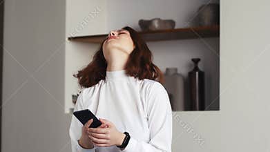 Displeased young business woman looking at smartphone screen, dissatisfied with bad news message, spam or scam sms