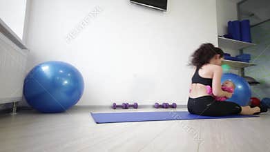 Young mother with daughter rolls on the mat with