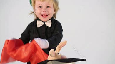 Little boy magician in suit shows focus with