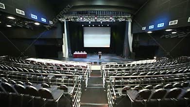 Rows of empty seats and illuminated stage in