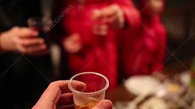 Plastic glasses with beverages in hands and