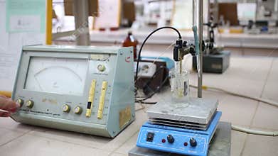 Male hand turns on and configures magnetic stirrer