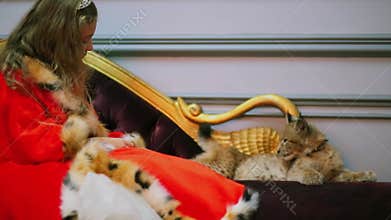 Young girl in red cloak afraid to pat calf of lynx