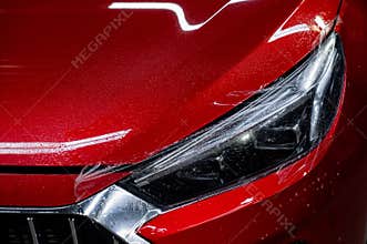 Close-up of a red car headlight with vinyl wrap.