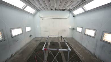 Empty paint-spraying booth with grey metal walls