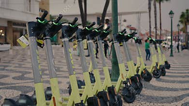Row of E-Scooters Parked on a City Street in Portugal for Urban Mobility