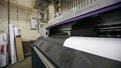 Plotter in printing house prints image on a large