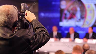 Back of videographer working on press conference