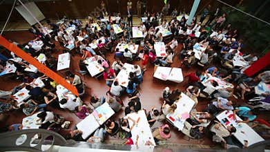 Many young people are sitting at tables in the