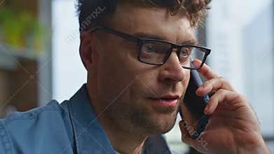 Smiling CEO speaking mobile phone at workplace closeup. Manager business call