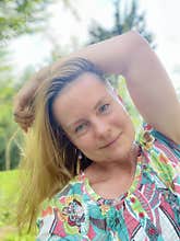 a blonde woman of 50 years old against the background of a park