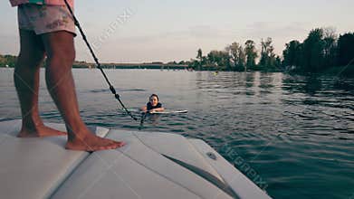 A girl stays afloat by holding on to a wakeboard.