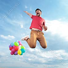 Casual man with balloons jumps in the air