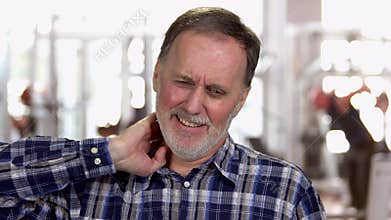 Handsome mature caucasian man suffering from neckache.