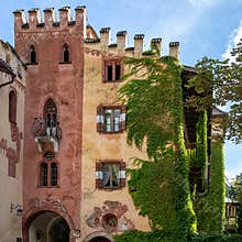 Creepers on facade of the Tiefenbrunner Castle Winery, tower courtyard of the winery in South Tyrol overgrown with wild wine.