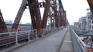 People traffic on railroad tracks leading over Long Bien Bridge