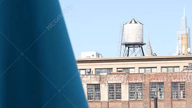 New York City industrial building exterior architecture, USA. Red brick facade. Rooftop water tower.