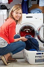 Woman Loading Clothes Into Washing Machine