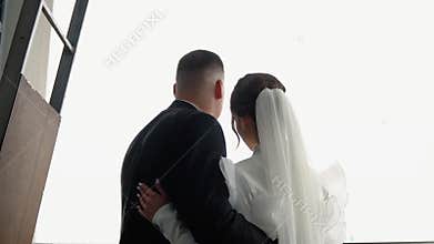 Bride and groom are standing and hugging