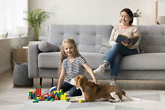 Caring dog owner grandma watching little kid from couch