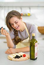 Happy young woman eating fresh cheese and olives