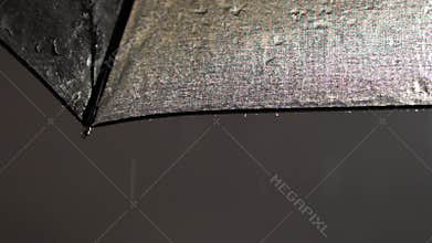 Raindrops on the umbrella raindrops falling. Black umbrella with raindrops slow motion. Drops and splashes. Rainy