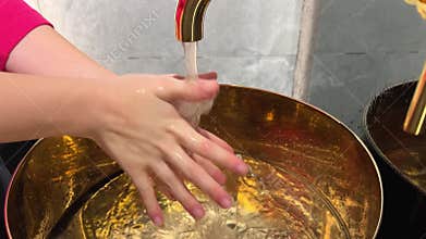 Golden washbasin wash hands lather with foam soap parts of body wash away with water wealth cleanliness neatness
