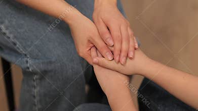 In a quiet moment of support, a woman's hands convey empathy and understanding to a pre-adolescent boy navigating