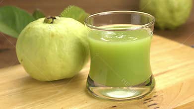 Zooming in fresh guava juice in transparent glass.