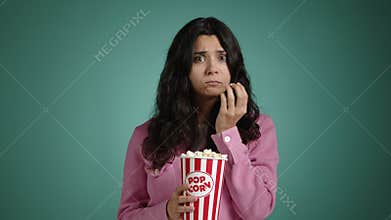 The girl with a puzzled look watches a movie.