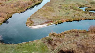 Aerial tilt view on river curve in autumn valley