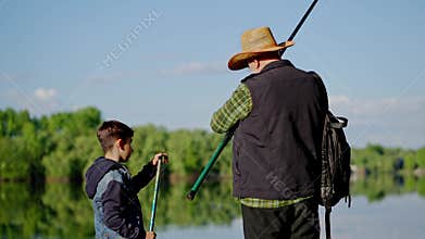 Rear view pensioner roll spinning. Fisherman with his grandson bringing fishing rod and come back home. Grandfather